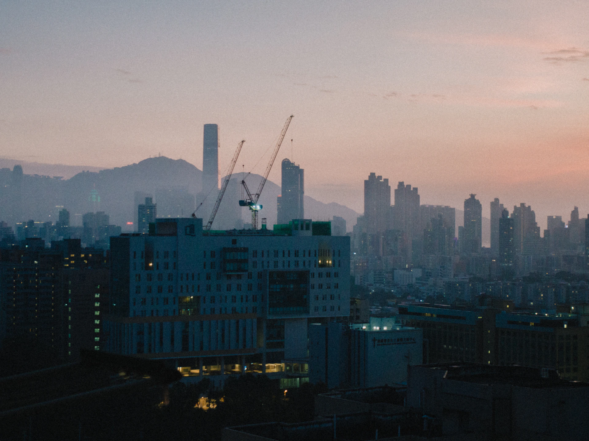 An elegant skyline at dusk featuring cranes and mining machinery, symbolizing JJSR Corporation's impact across India's infrastructure and mining sectors.