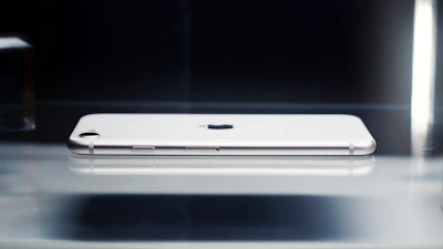 Side view of a modern smartphone showing its thin profile and smooth edges on a clean surface.