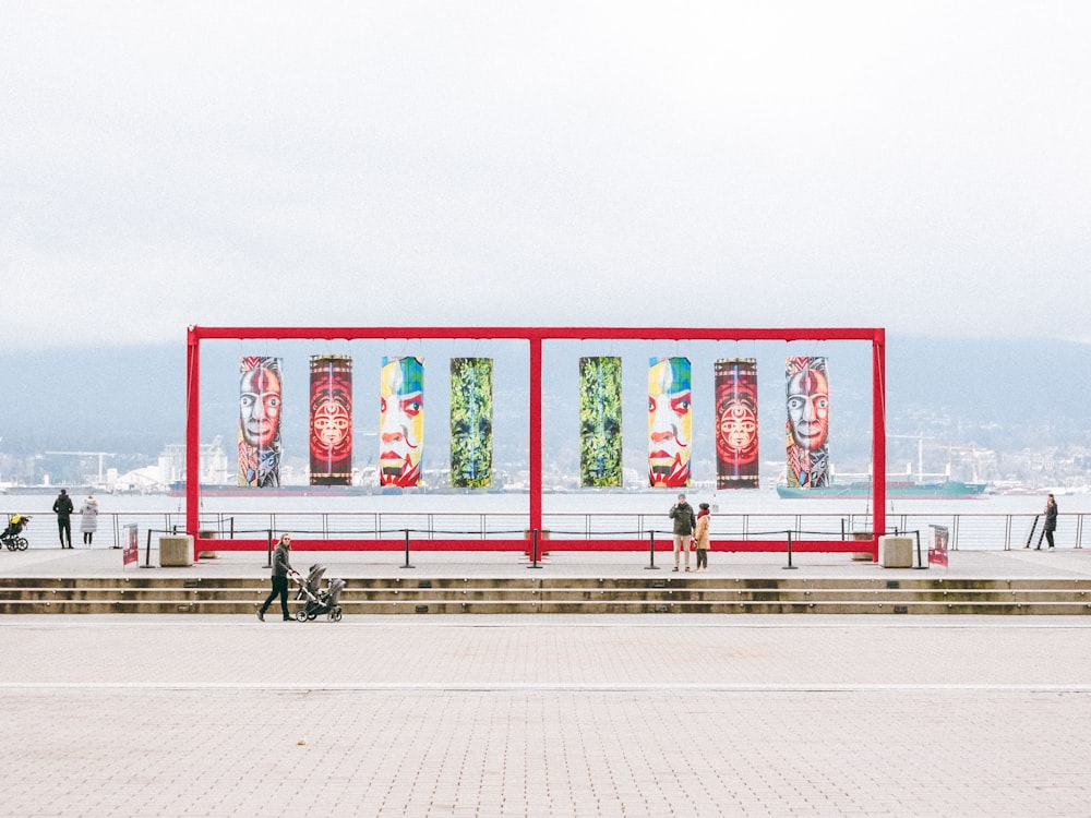 a group of people standing around a red structure