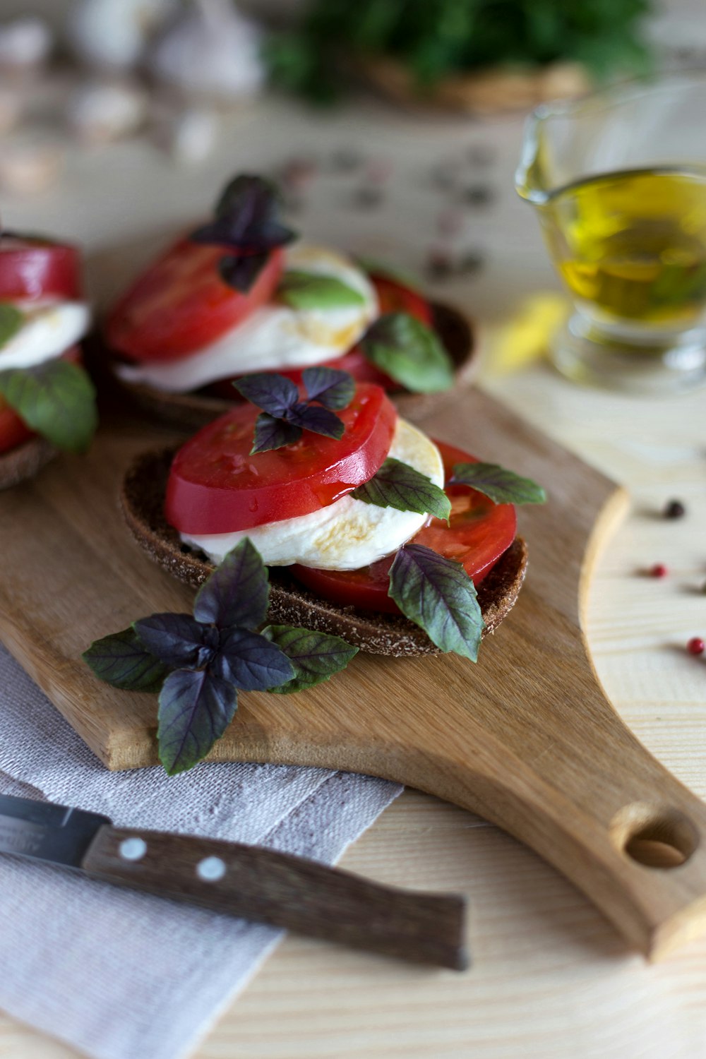 ein hölzernes Schneidebrett mit geschnittenen Tomaten und Käse