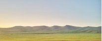 A serene landscape showing open land ready for development under a clear sky.