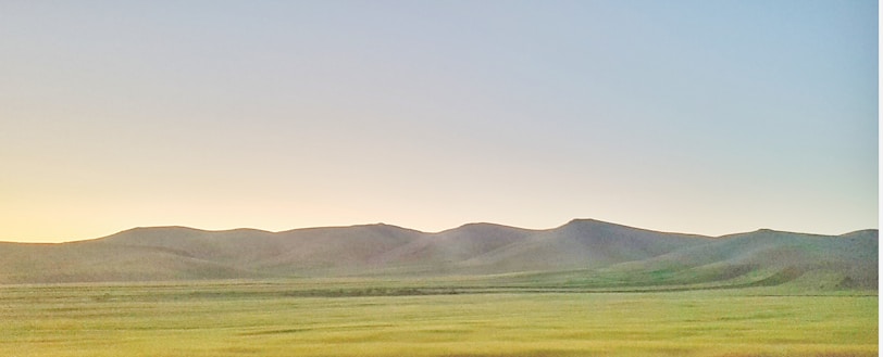 A serene landscape with rolling hills under a clear sky.