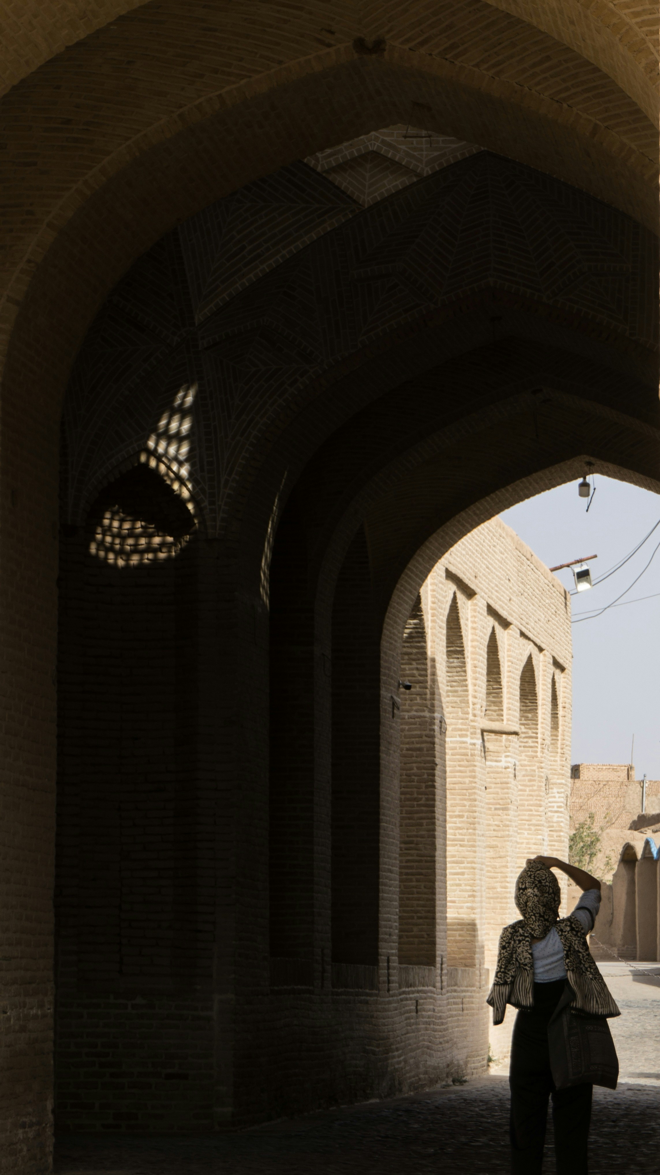 a woman standing under an archway in a building