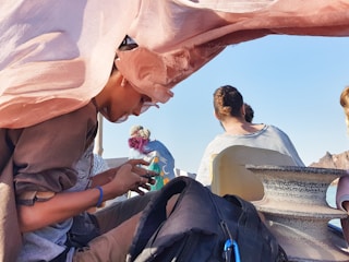 A sailor using a digital payment app on a boat deck with the sea in the background.
