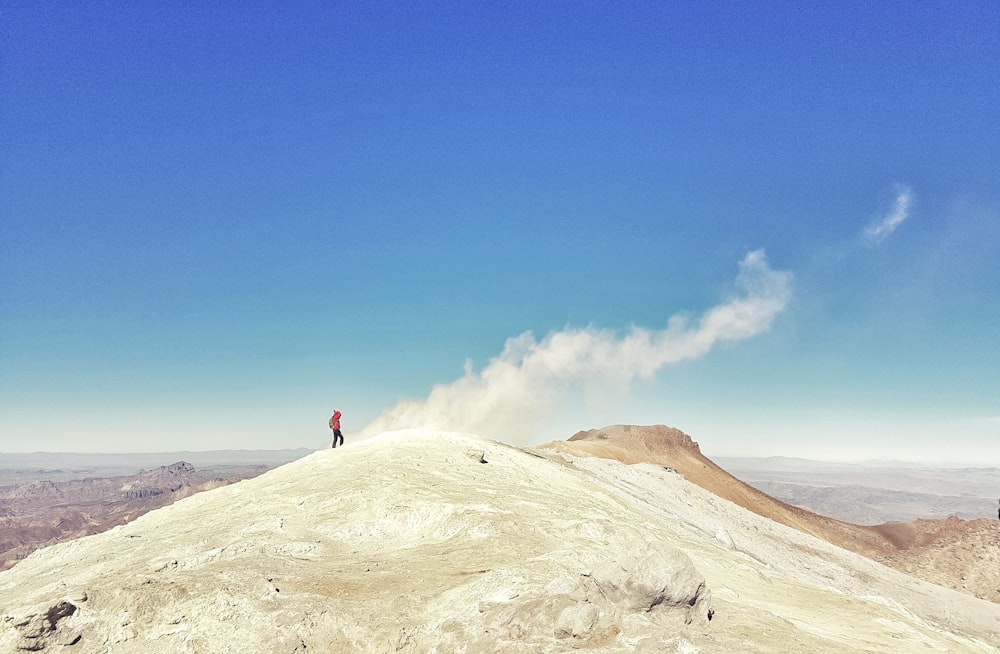 Un uomo in piedi sulla cima di una montagna bianca