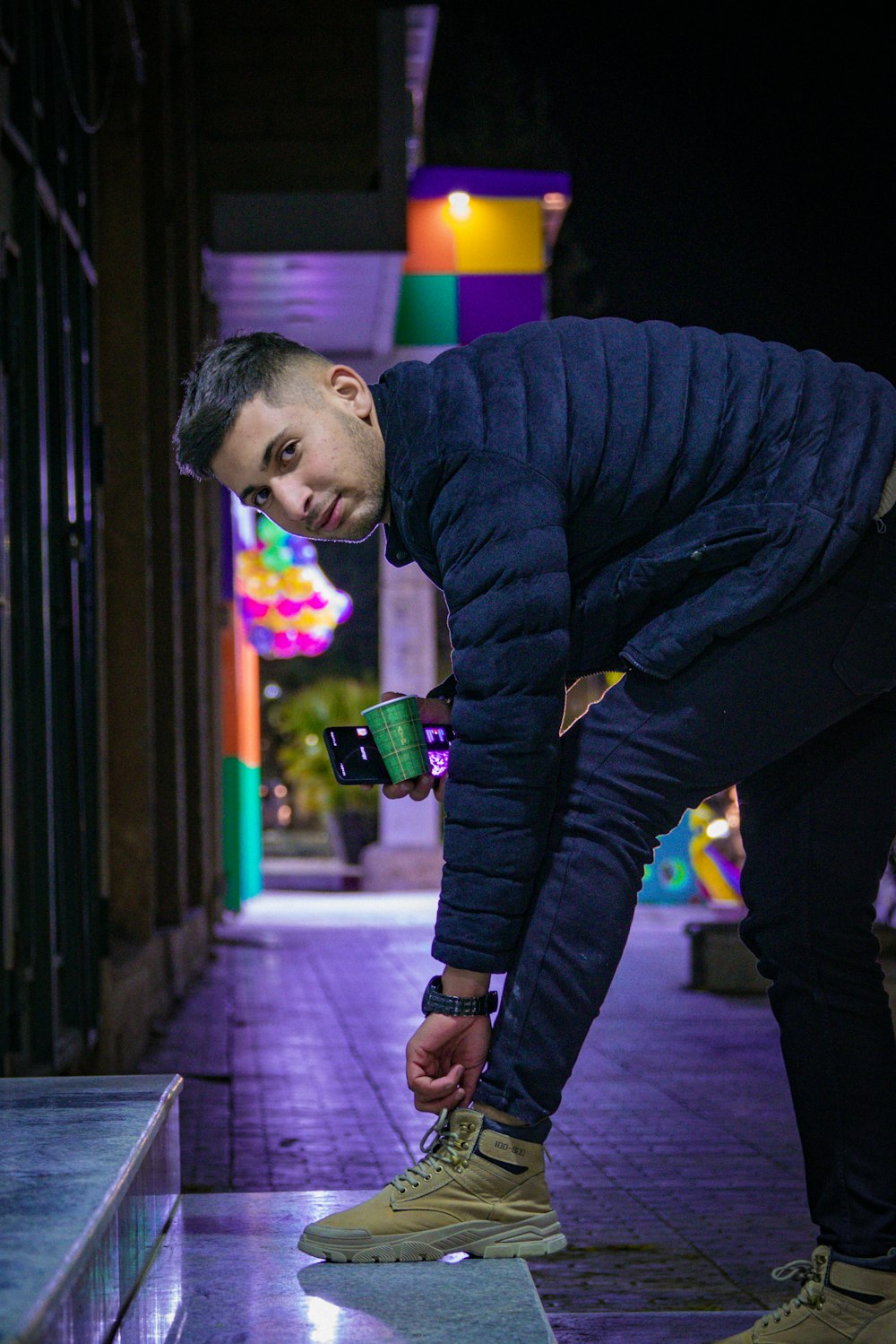 a man in a blue jacket looking at a cell phone