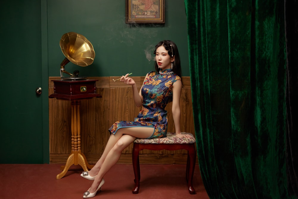 a woman sitting on a chair smoking a cigarette