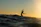 Surfer catching a wave at sunset on the coast of Gran Canaria.