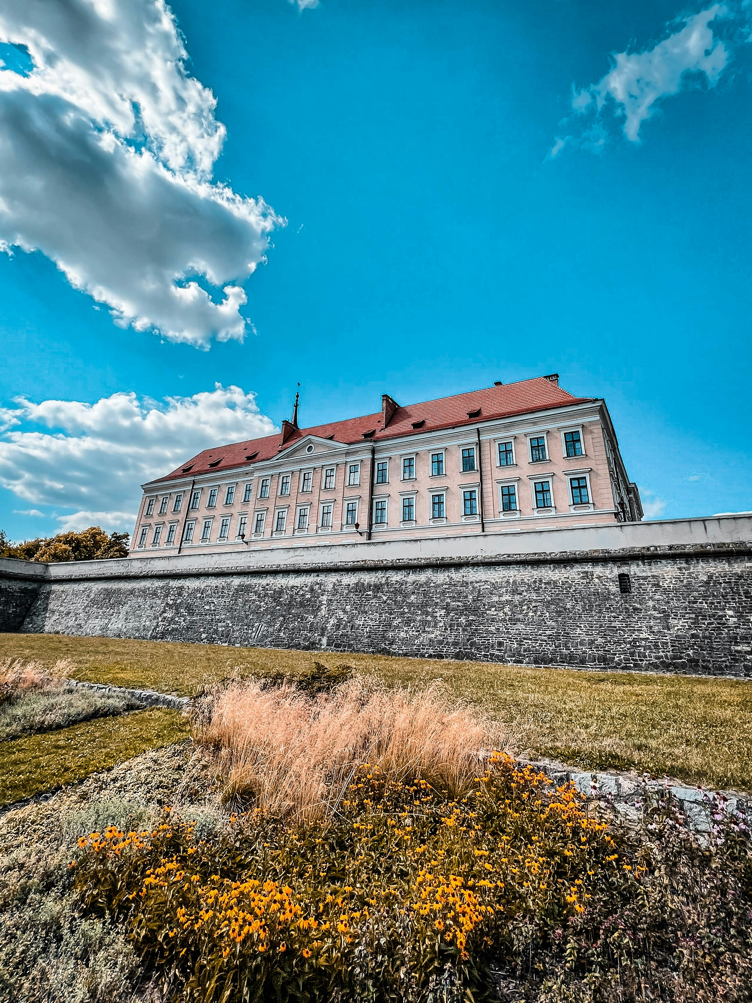 Un gran edificio sentado en la cima de un exuberante campo verde