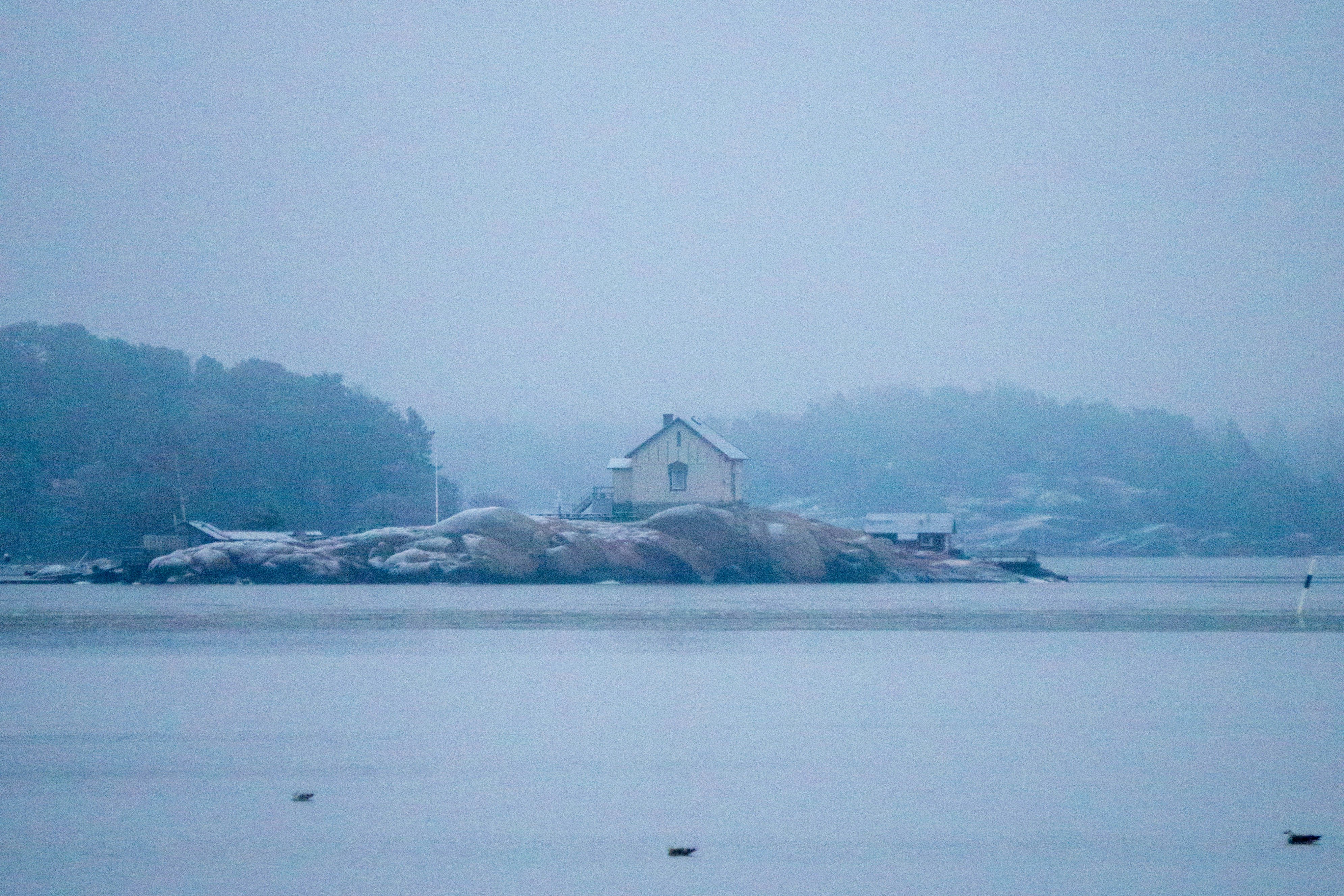 a house on a small island in the middle of a lake