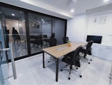 a conference room with a wooden table and black chairs