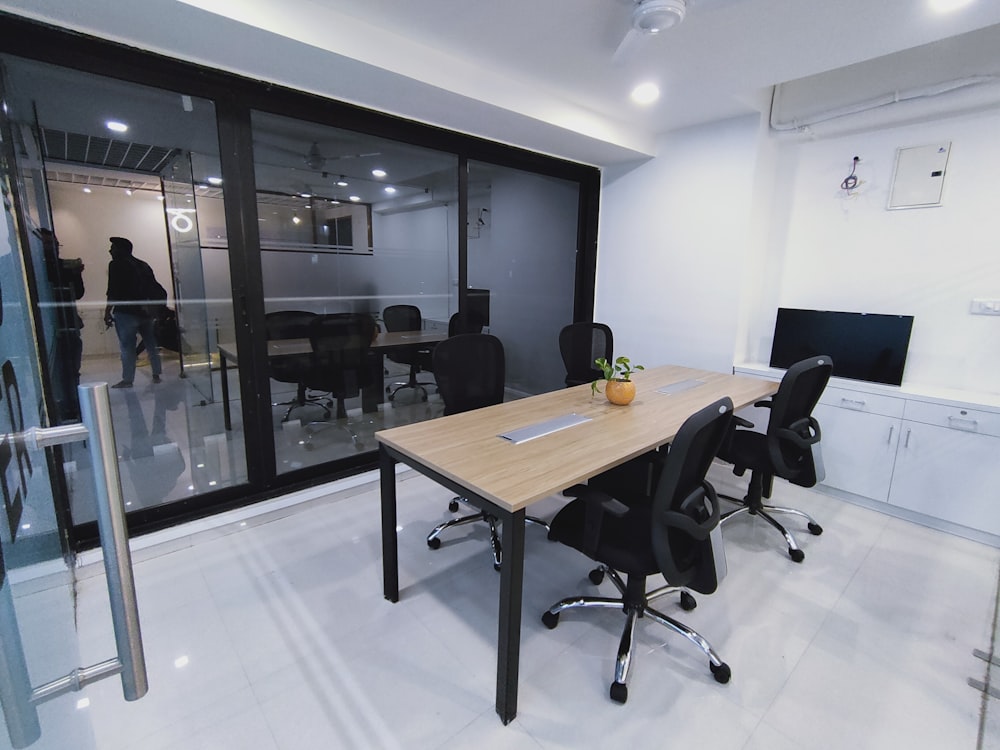 a conference room with a wooden table and black chairs