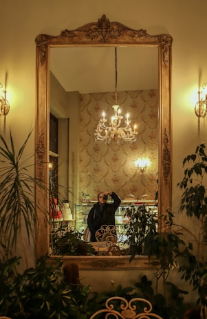 An ornate antique mirror reflecting a stylish interior.
