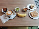 A colorful breakfast package with fresh fruits, pastries, and a coffee cup on a wooden table