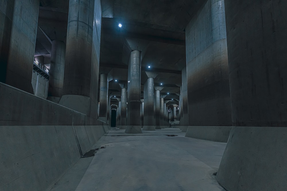 a dimly lit hallway in a building with columns