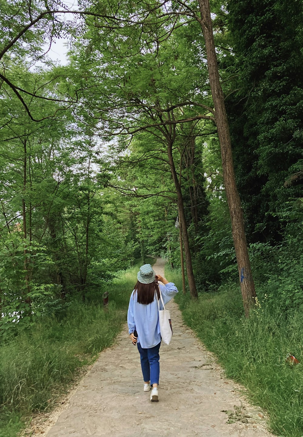 a woman walking down a path in the woods