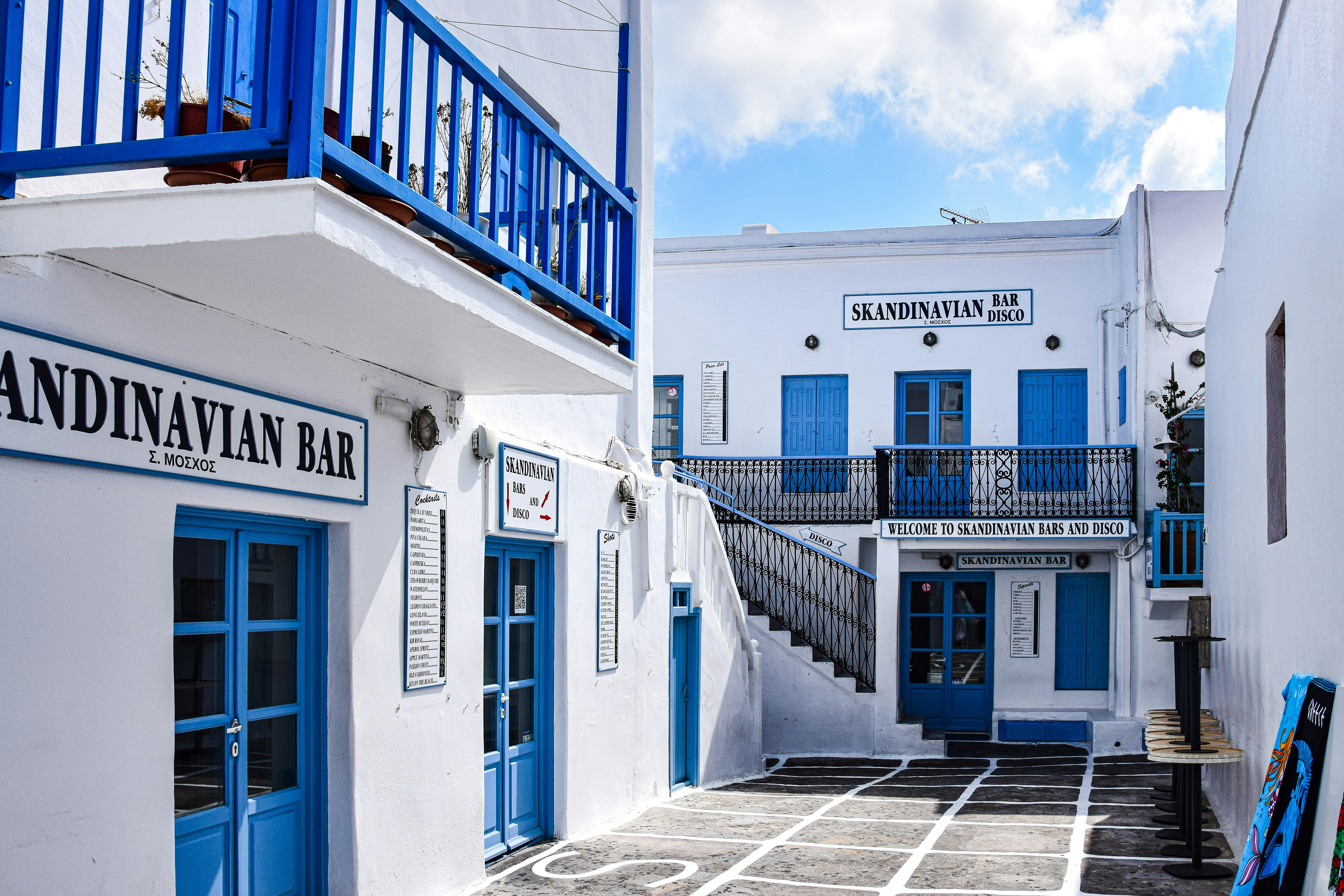 A white building with blue doors and a blue balcony