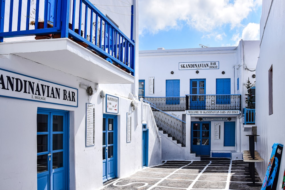 a white building with blue doors and a blue balcony