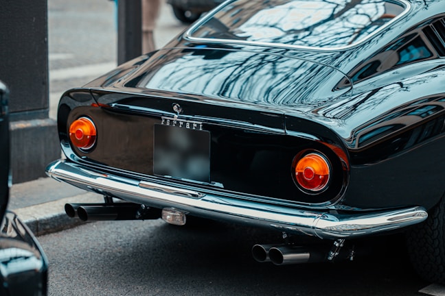 A classic black coupe with polished chrome details gleaming in the afternoon sun.