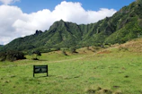 A scenic mountain landscape with a film crew setting up equipment.