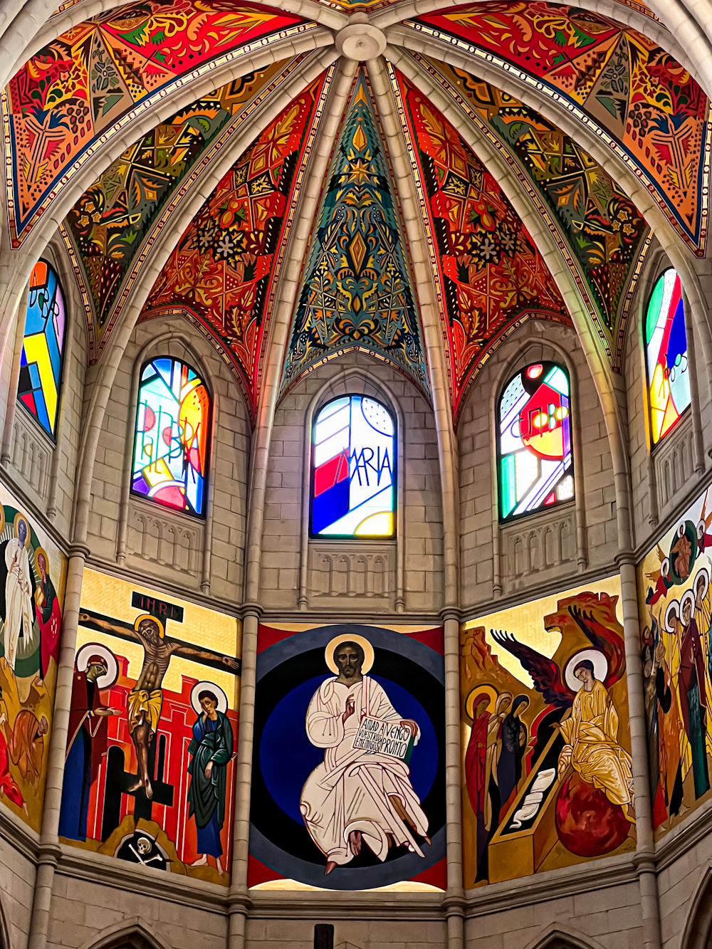 a large cathedral with stained glass windows and paintings on the ceiling