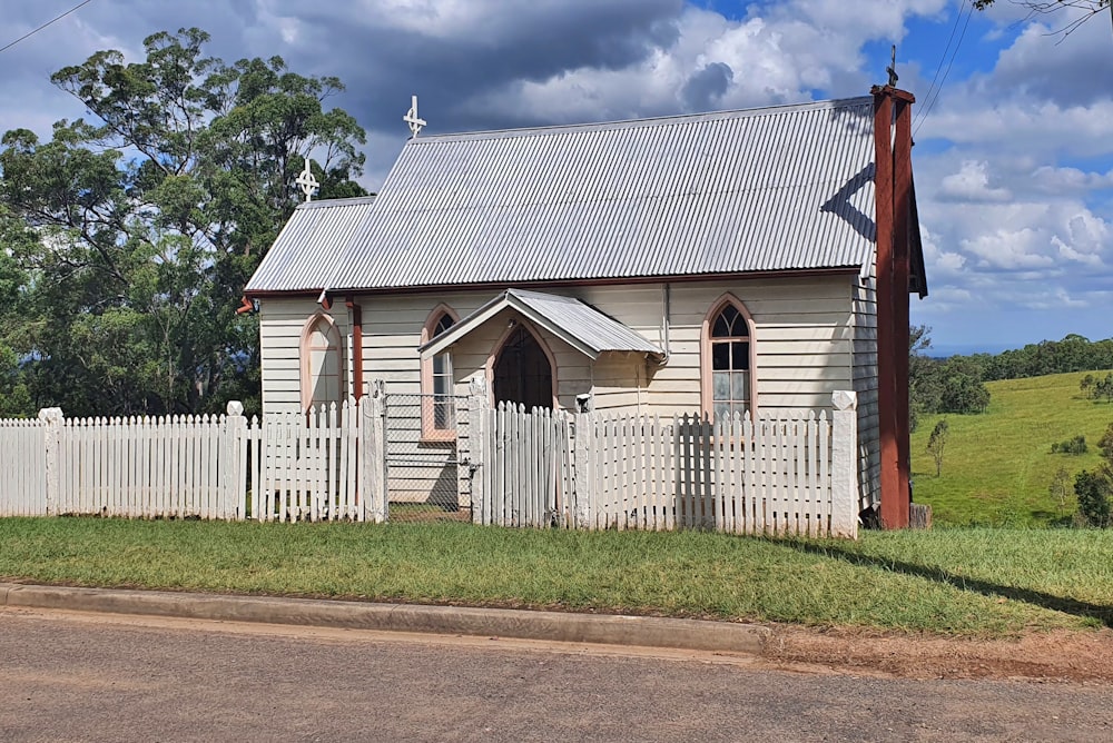 a small church with a white picket fence