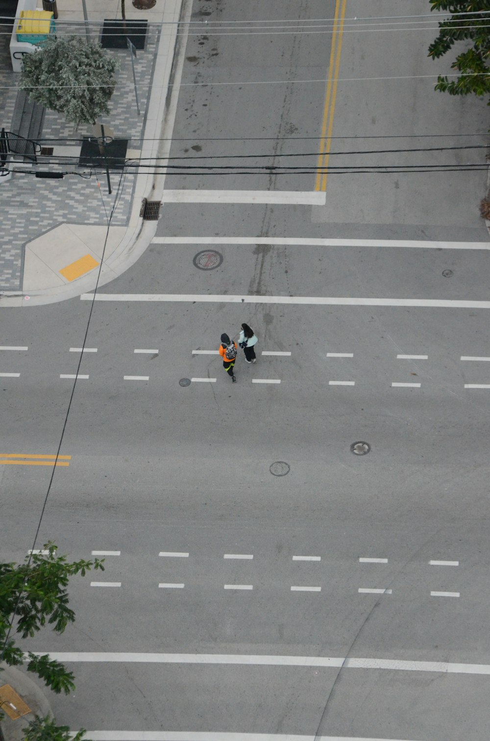 an overhead view of a city street with two people on motorcycles