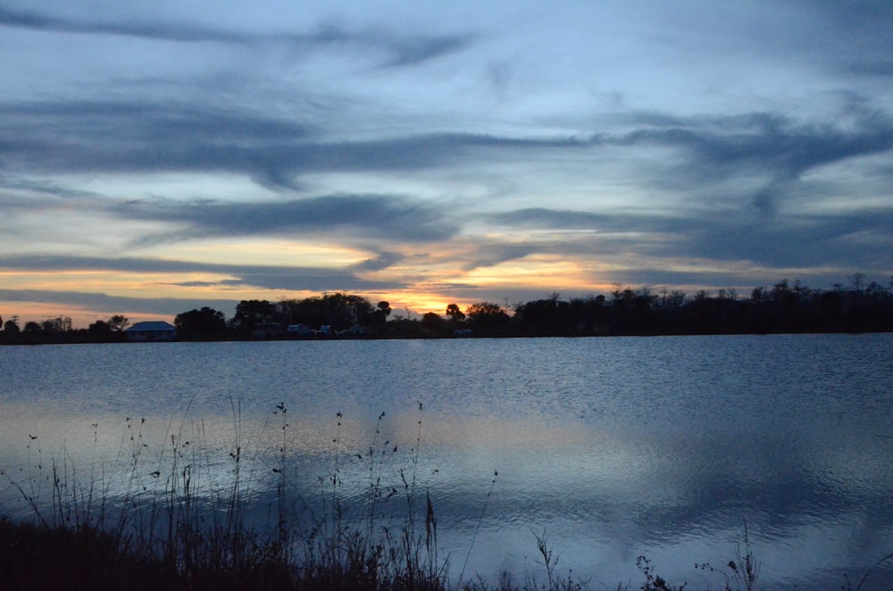 a large body of water with a sky in the background