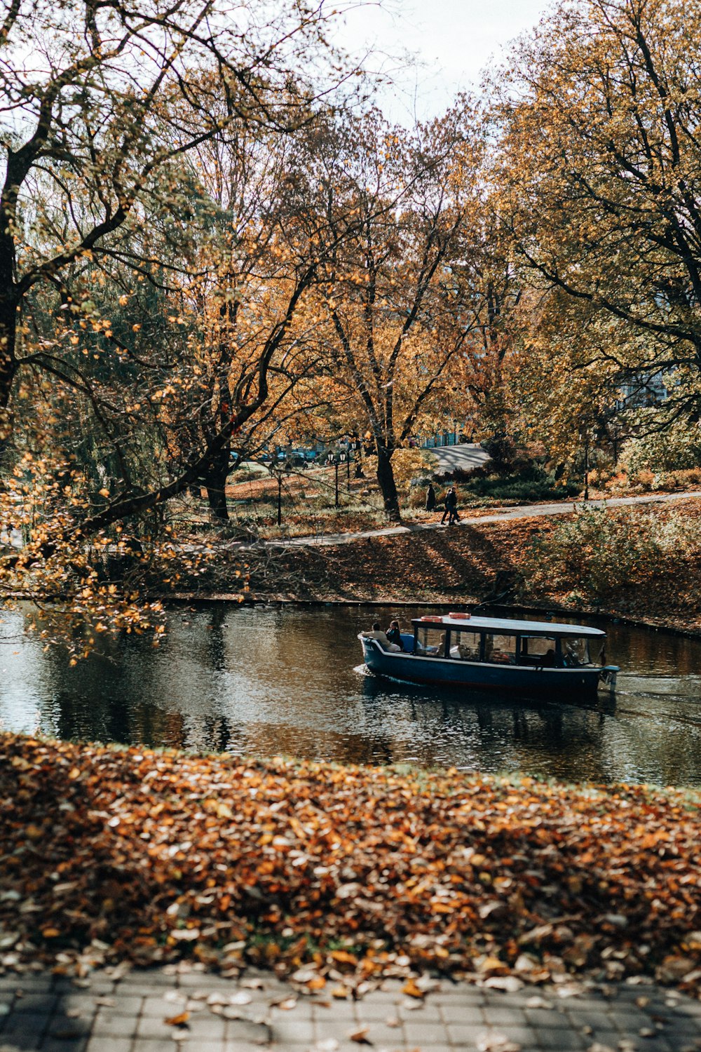 a boat floating on top of a river surrounded by trees