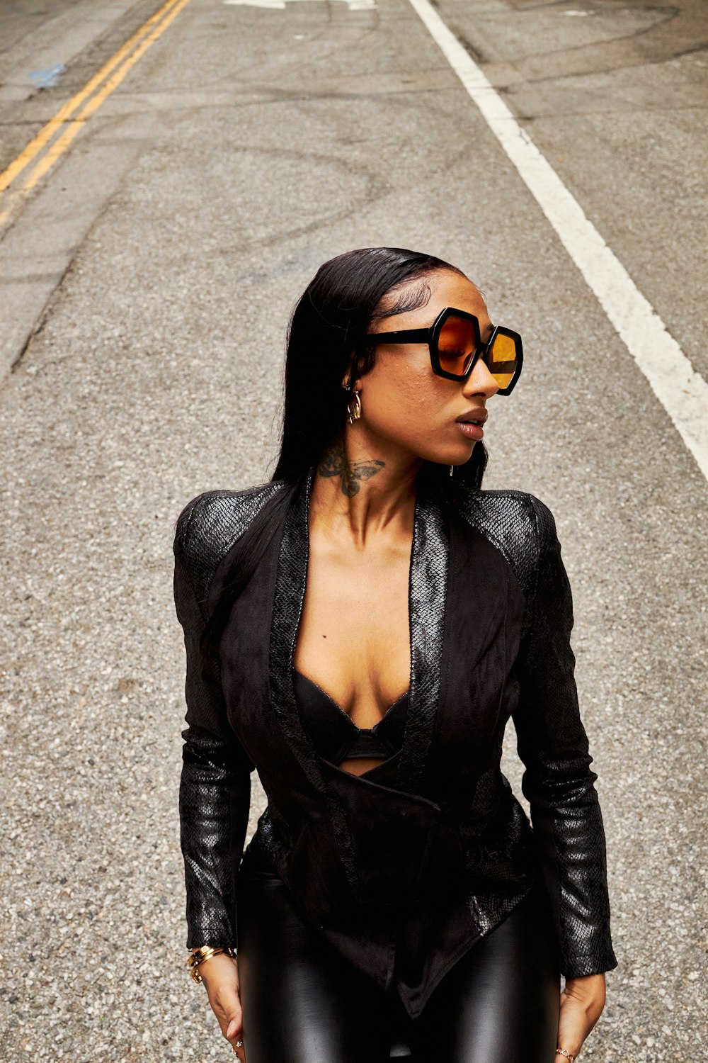a woman in a black outfit and sunglasses
