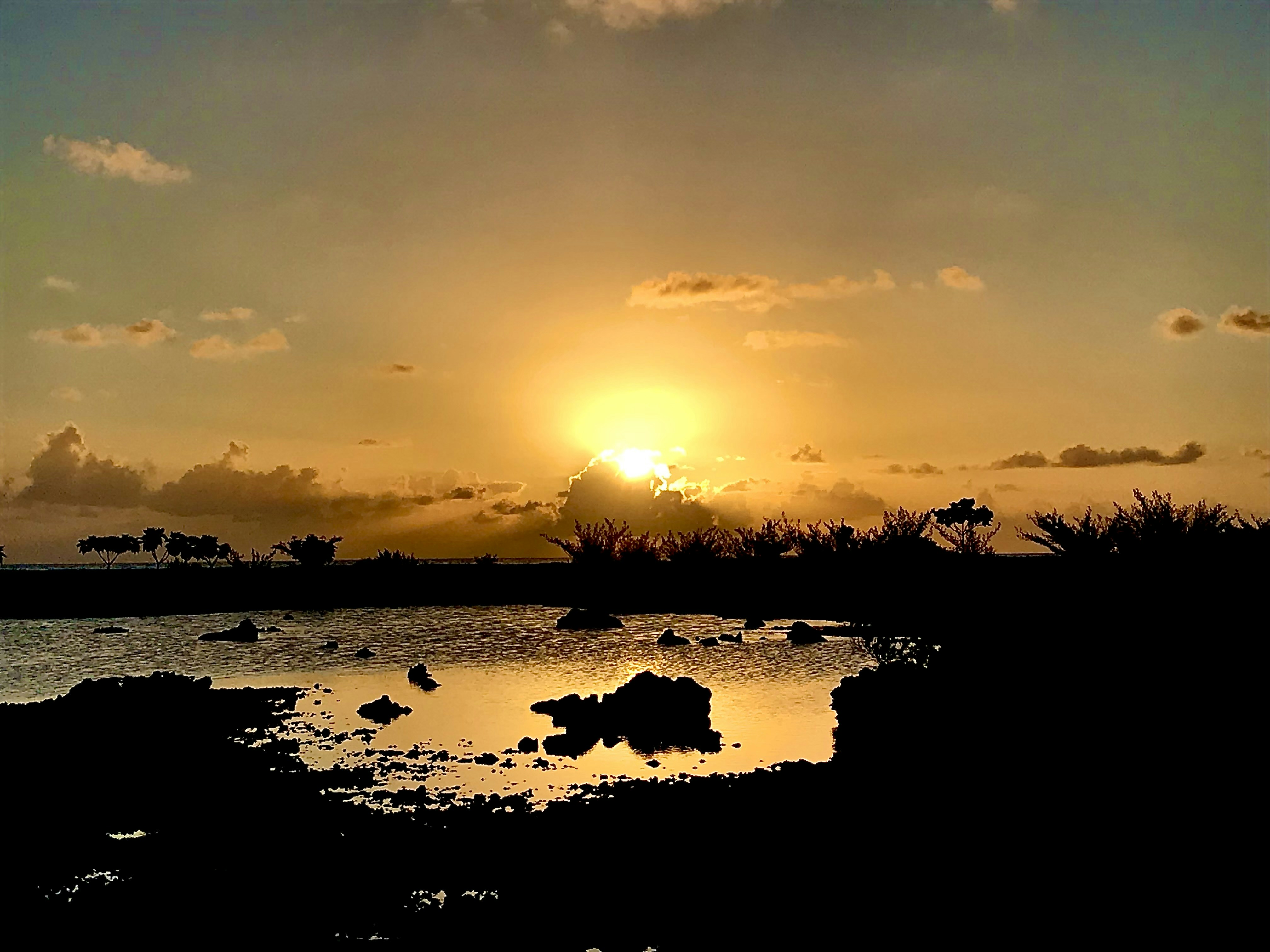 the sun is setting over a body of water