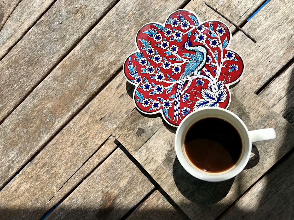 a cup of coffee sitting on top of a wooden table