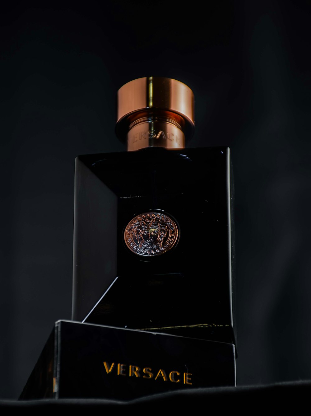 a bottle of perfume sitting on top of a black box