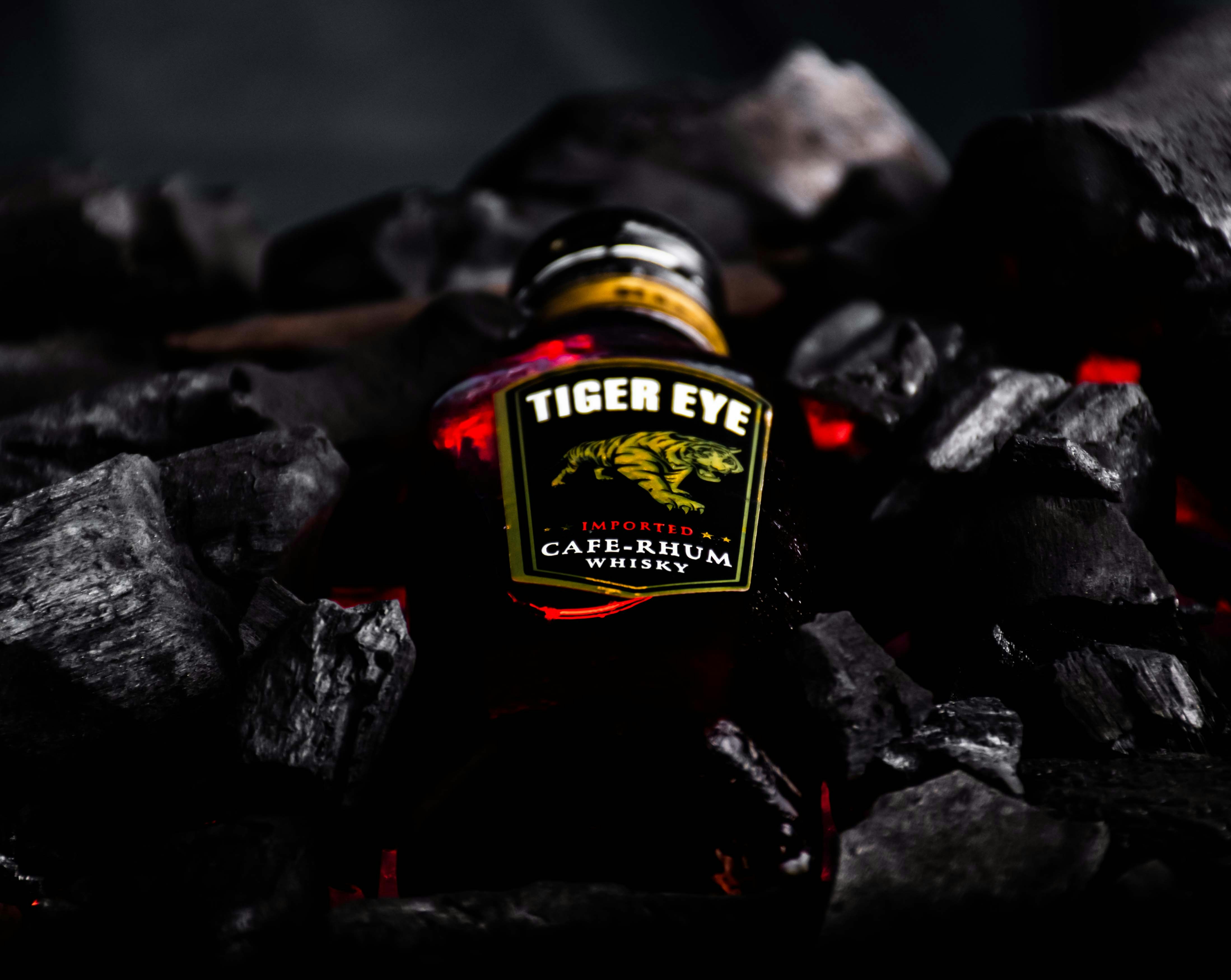 a bottle of beer sitting on top of a pile of rocks