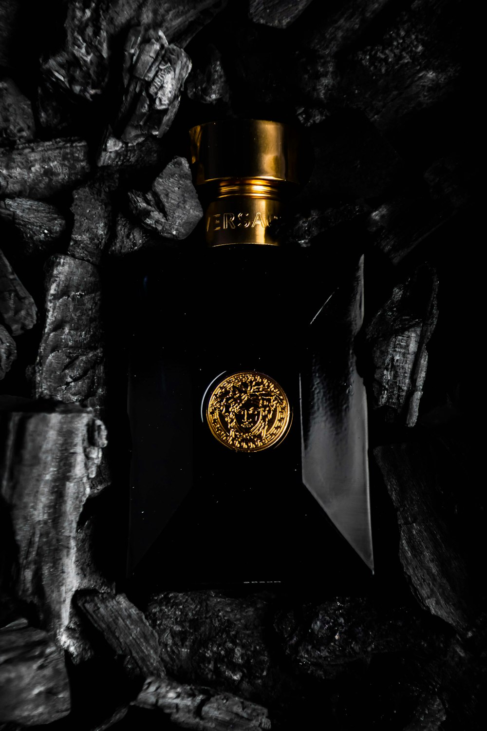 A black bottle with a gold emblem on it photo – Free Versace Image on  Unsplash