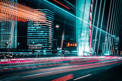 Image showing futuristic cityscape with connected vehicles at night, illuminated with blue electric lights.
