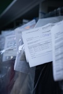 Several documents with Cyrillic text are visible, placed in a stack with clear plastic packaging around them. The focus is on a receipt or invoice in Russian, featuring printed and handwritten text.