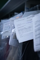 Several documents with Cyrillic text are visible, placed in a stack with clear plastic packaging around them. The focus is on a receipt or invoice in Russian, featuring printed and handwritten text.