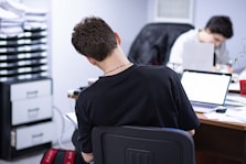 a man sitting at a desk in front of a laptop computer