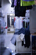 A busy warehouse with racks of assorted clothing ready for shipment.