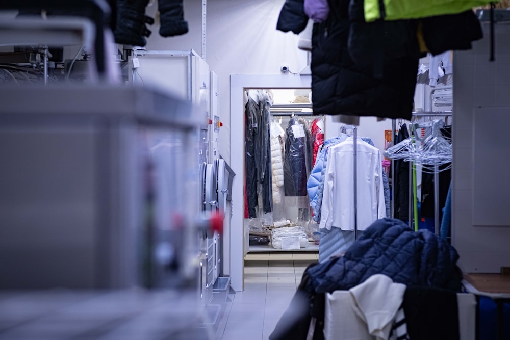 a room filled with lots of clothes and a mirror