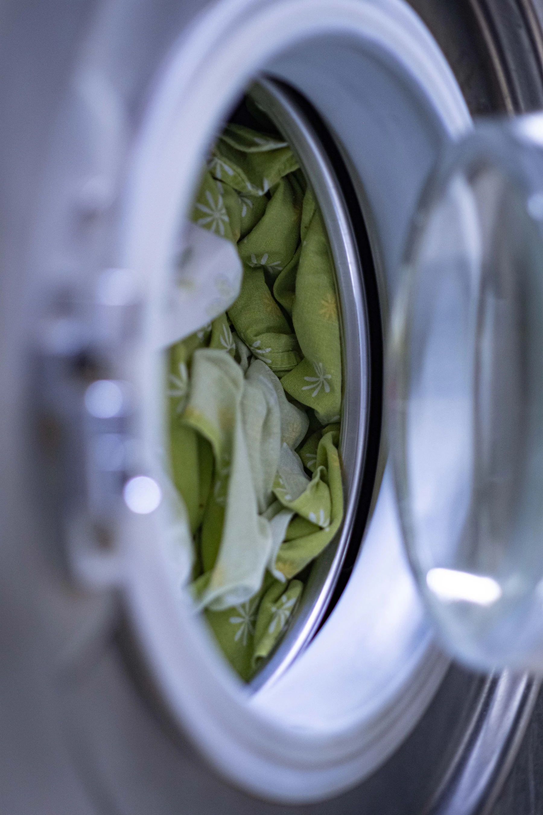 Close-up of a washing machine drum with garments and water during a wash cycle