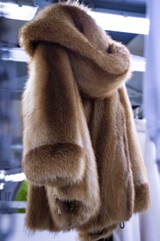 a fur coat hanging on a rack in a store