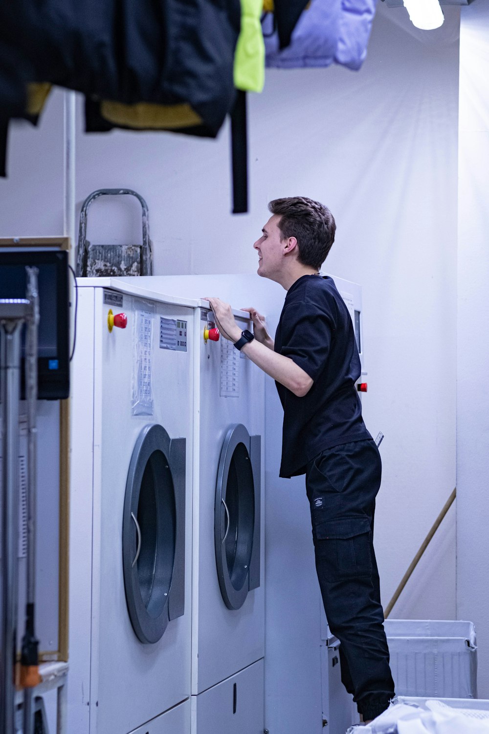 a man standing on top of a washing machine