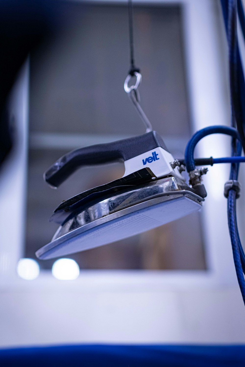 a close up of a stapler with a blue cord