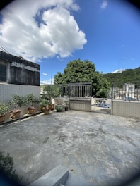 A vibrant terrace garden bursting with colorful flowering plants and neatly arranged pots under a clear blue sky.