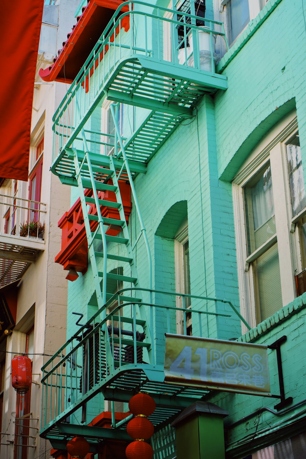 a green building with a red fire escape