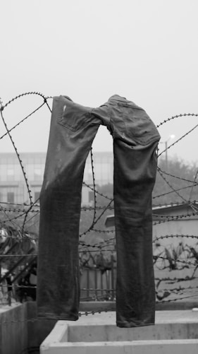 a pair of jeans that are tied to a fence