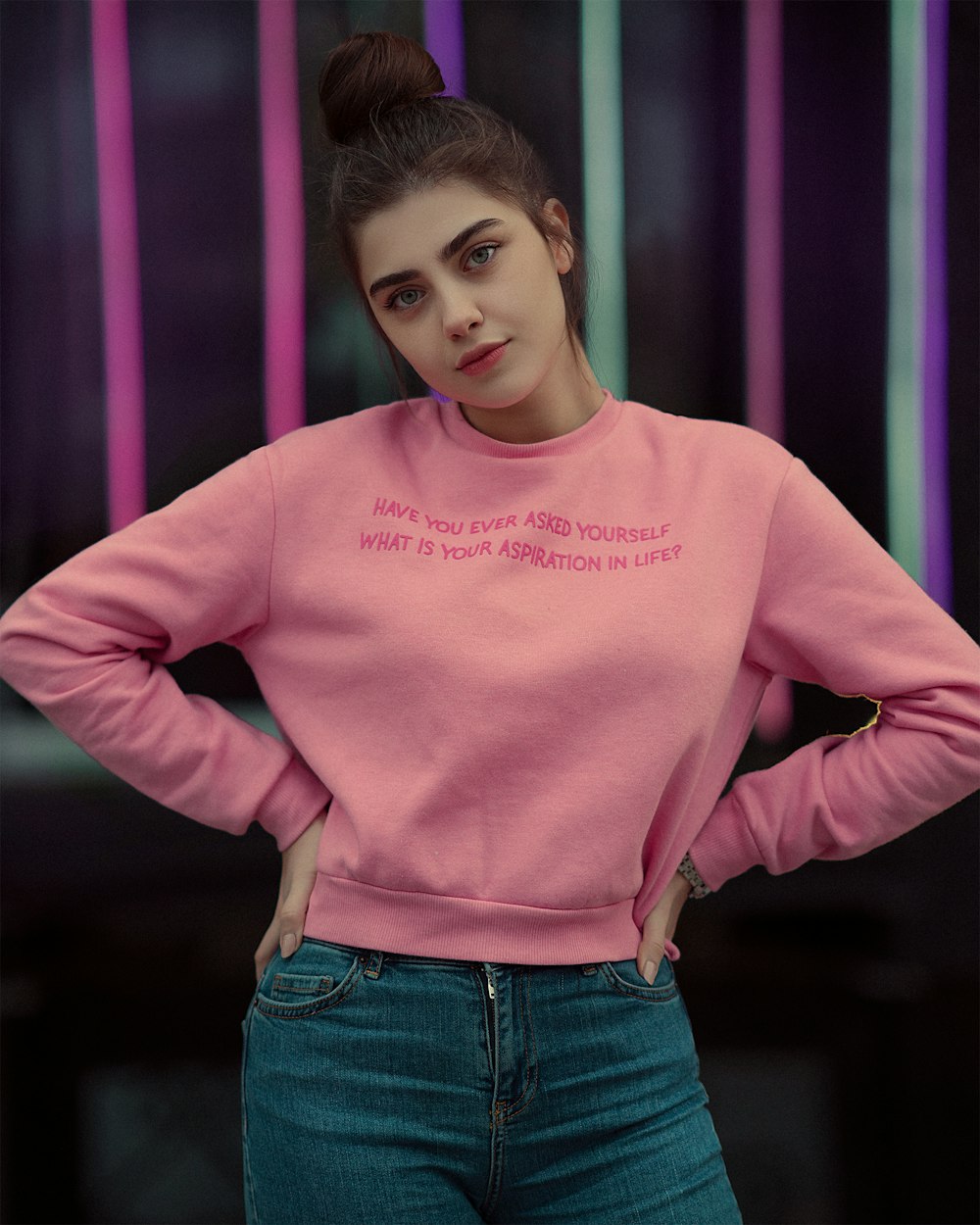 a woman wearing a pink sweatshirt with writing on it