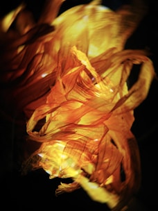 An artistic close-up of a matador’s cape swirling in ochre and orange hues.